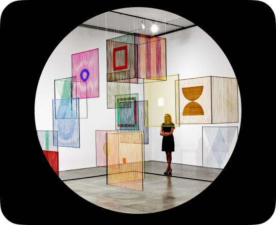A woman, immersed in the contemplative canvas of art, conjuring visual tapestries that mirror the essence and values of the company.