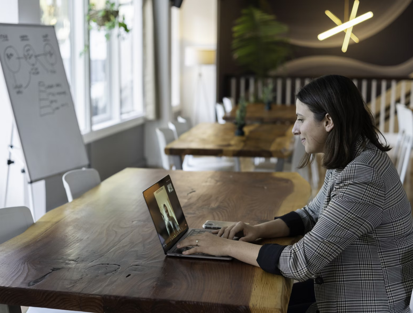 A woman engrossed in her laptop, diligently immersed in her tasks.